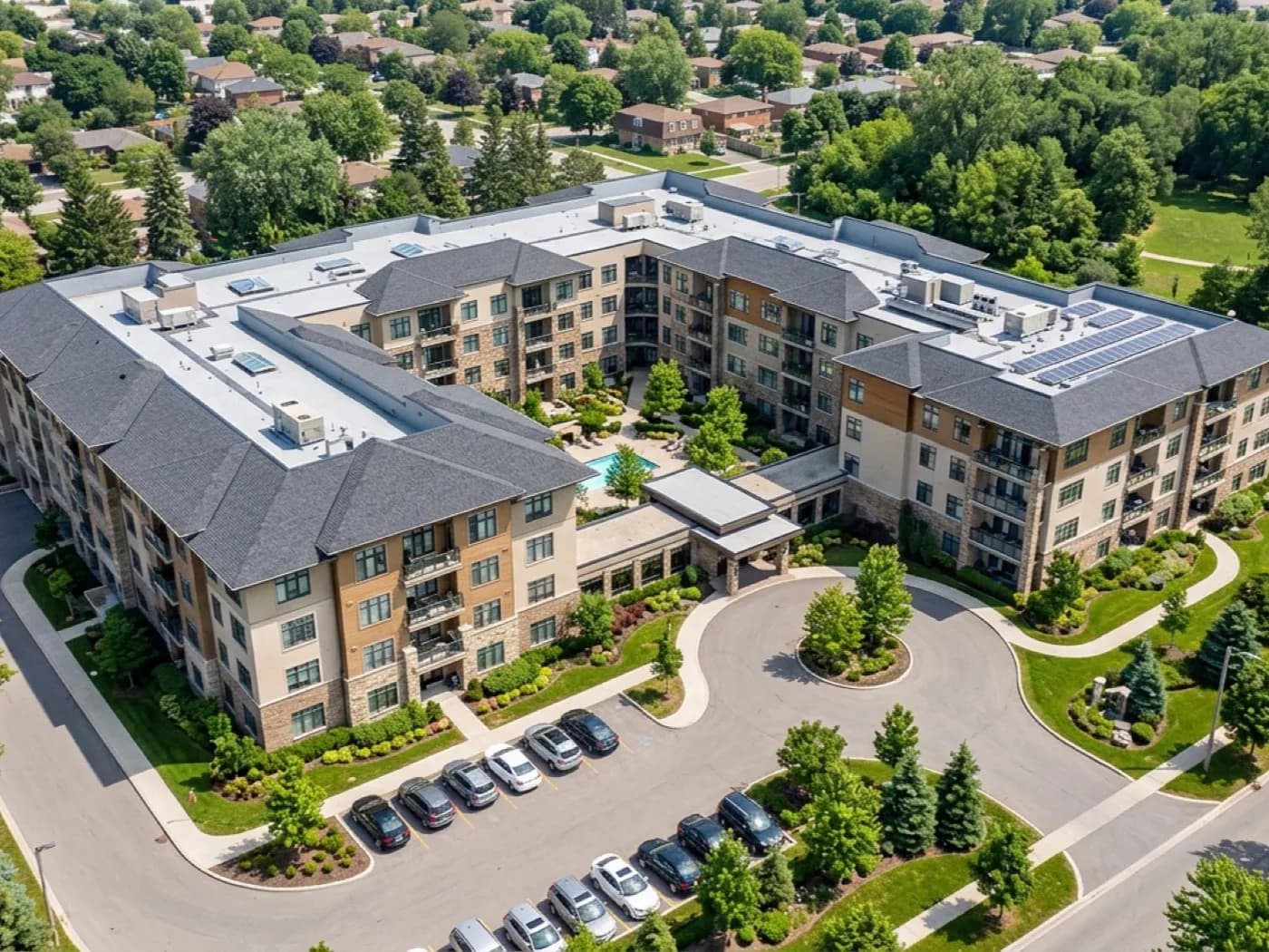 Aerial view of a building's roof, elevations and surrounding grounds photographed together from a drone
